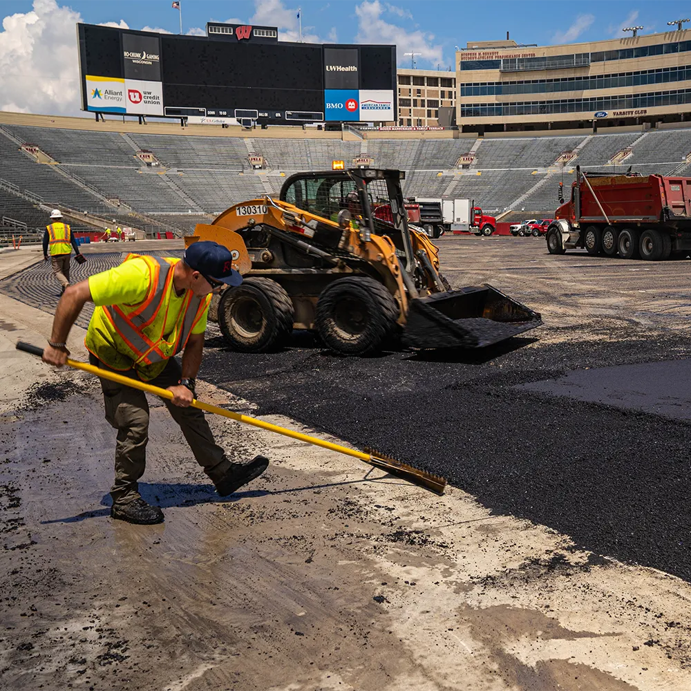 Construction worker smoothing pavement