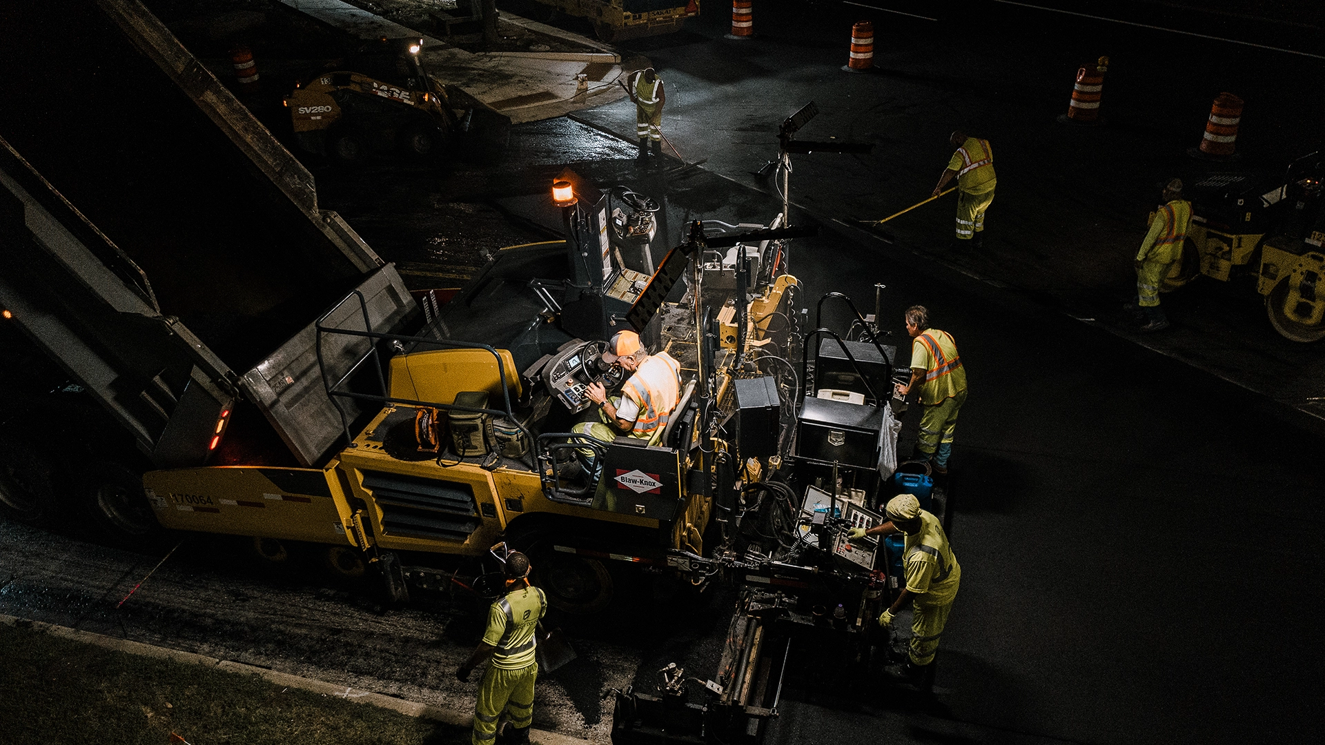 construction workers with heavy equipment at night